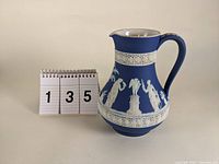 Photo showing front and side view of Wedgwood jasperware pitcher with number 135 beside it for scale.