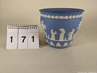 Front view of Wedgwood light blue jasperware cache pot with white decorative reliefs and size reference.