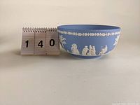 Front view of light blue Wedgwood Jasperware bowl illustrating classical white relief pattern and oak leaf border.