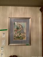 Overall view of framed painting hanging on wall with adjacent labels.