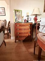 Full front view of the cabinet with objects on top and surrounding furniture.