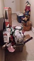 Photo showing Christmas tree box, wrapped items, plastic bins, baskets, and boxed decorations.