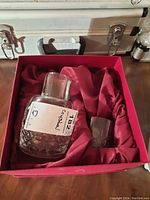 Lead crystal decanter and one glass in red satin-lined presentation box.
