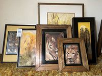 Six framed art pieces arranged together showing animal portraits and floral abstracts with varied frame styles.