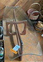 Angled overhead view showing curved glass top and walnut base