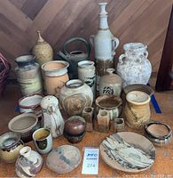 Wide front view of all 24 earthenware pieces arranged on floor