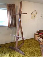 Full frontal view of the large wooden easel showing the adjustable supports and foldable A-frame design.