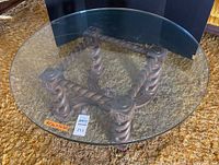 Full view of coffee table showing round 40-inch diameter glass top and turned wood base.