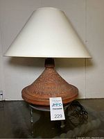Full view of the terra cotta table lamp showing texture, shape, and shade.