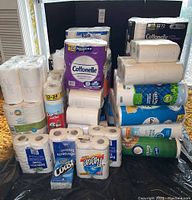 Various packs of toilet paper stacked and grouped together showing different brands and quantities