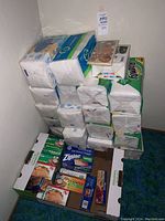 Stacked unopened packs of Bounty paper napkins along with boxes of sandwich bags beneath