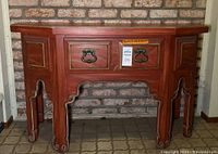 Front view of the vintage wooden console table showing the central drawer and six legs with intricate borders.