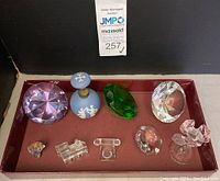 Full view of all crystal decor items and Wedgwood perfume bottle in tray with auction tag.