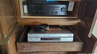 Sony SLV-D350P DVD/VHS player with cables on a wooden drawer shelf