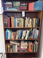 Full bookshelf of assorted books including historical, technical, and western genres, with some hardcover and some paperback books.