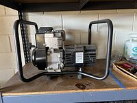 Side view of generator showing black metal frame, engine and pull start.