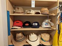 Photo of shelf with 10 hats including cowboy hats, straw hats, and ball caps as described.