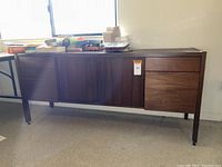 Full view of Standard Desk wood veneer office credenza cabinet showing center sliding doors and drawers on each side.