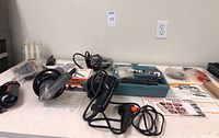 Full view of the tools and accessories spread out on a table including cords and power tools.