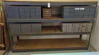 Full front view of 4-shelf steel and particle board shelving unit showing empty storage drawers on shelves.