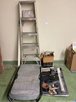 Full lot view including Keller aluminum step ladder, Rubbermaid trolley on the floor, gloves, tarp, multi-drawer organizer, and tape.