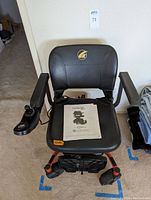 Front view of power chair showing seat, backrest and joystick controller on right armrest