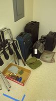 Overview of suitcases, luggage stands, shoe bags on the floor corner