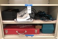 Shelf view showing red Milwaukee case, Skilsaw circular saw, blue Makita case and tools