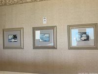 Three framed watercolor paintings depicting beach scenes hung on wall