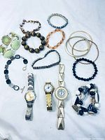 All bracelets and watches laid out on white background