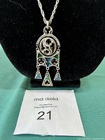 Full front view of necklace pendant and chain against black background