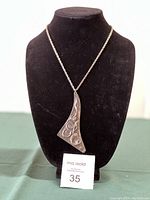 Full view of pendant on display mannequin with adjustable chain visible.