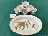 Photo of the oval casserole dish in front with six custard dishes stacked in pyramid behind it on a green tablecloth.