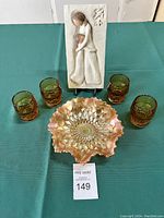 Full lot showing the Willow Tree plaque, ruffled carnival glass dish, and four amber tinted glasses arranged on a green cloth.