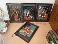 Four framed glass paintings depicting seasons Winter, Fall, Spring, Summer in traditional German style, arranged standing and one laying flat on cardboard.