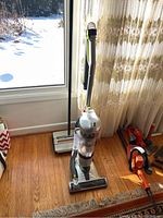 Full view of the vintage Bissell Gemini powerless vacuum cleaner showing handle and base with transparent dust area.
