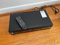 Top side view of Toshiba VCR device with remote control placed on top.