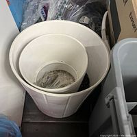 Top-down view of the huge white ceramic floor planter nested with a smaller planter inside, showing the interior and flared rim design.