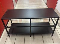 Front and side view of the black Ikea Vittsjö TV bench showing structure and shelves