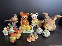 Main group photo of all porcelain and ceramic decorative items including figurines, salt & pepper shakers, planters, and paper-mâché basket