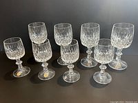 Full set of 8 glasses, 4 taller wine glasses and 4 smaller sherry glasses, clear crystal with vertical cut pattern and faceted stems.