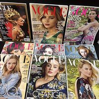 Top-down photo showing nine Vogue magazines laid out overlapping on a flat surface featuring covers with several celebrities and models including Jennifer Lawrence, Adele, and others.
