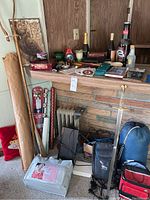 Wide view of bundle laid out showing walking cane, wrapping paper, folding chair, bottles, and other items on mantel and floor.