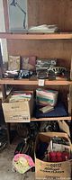 Shelf holding cardboard boxes of papers, books, and small household items including fabric bags and storage boxes.