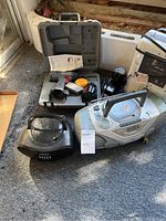 Photo showing all items of the lot arranged on carpet including radios, heater, and power tool kit