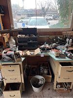 Wide view of corner desk with assorted tools including toolbox, brushes, and grinding discs.