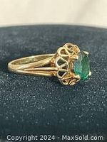 Side and top view of 10K gold ring with green stone showing the floral crown setting and stone clarity.