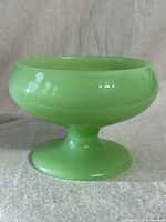 Side view of green jadeite glass candy bowl showing shape and height.