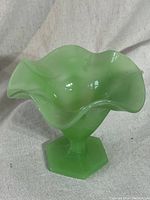Front view showing ruffled top edge and wide opening of the green jadeite glass fruit bowl on hexagonal base