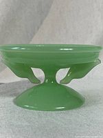 Side view of the vintage jadeite love bird bowl showing love bird supports and pedestal base.